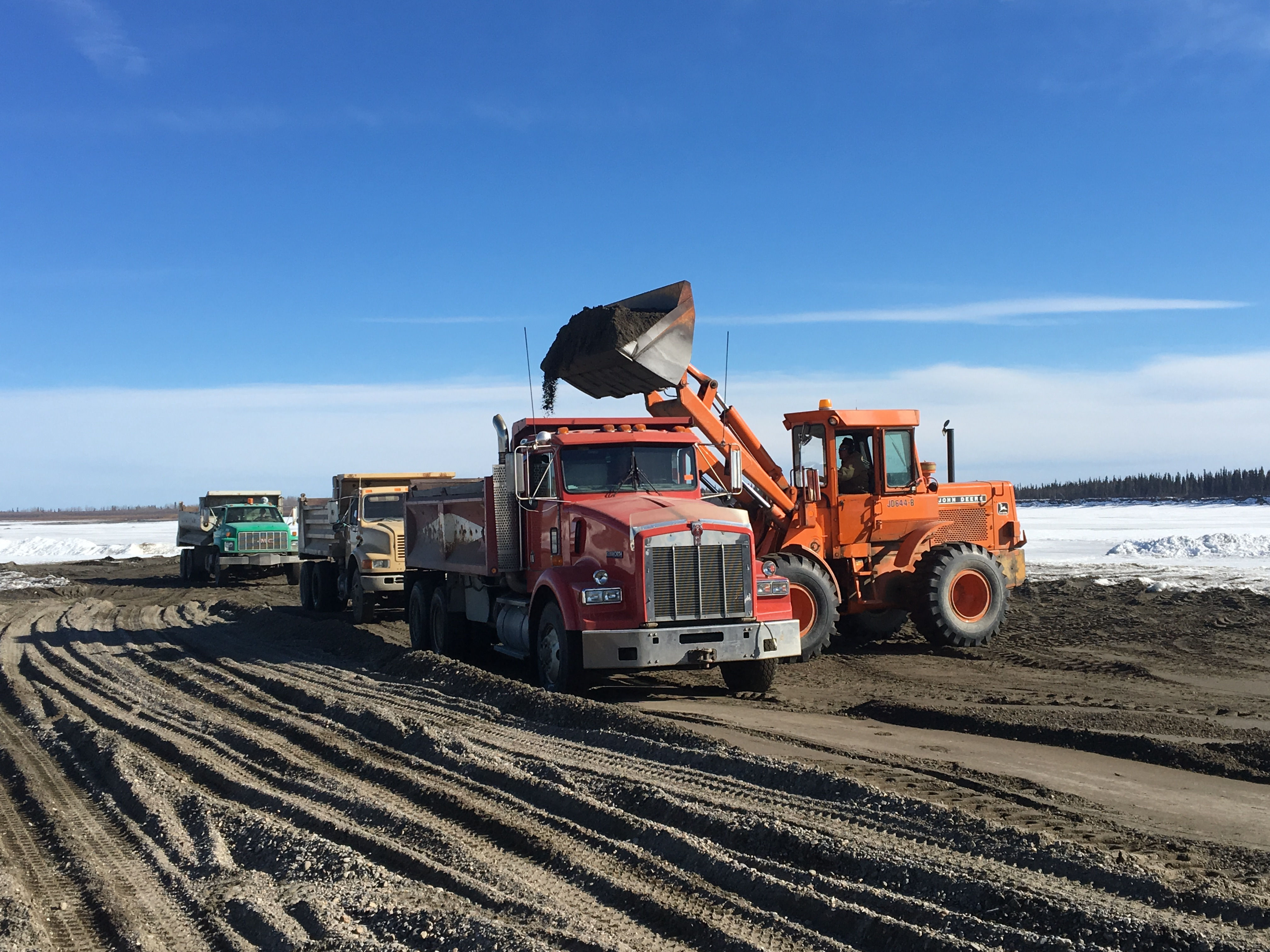 Truck and excavator working in winter conditions