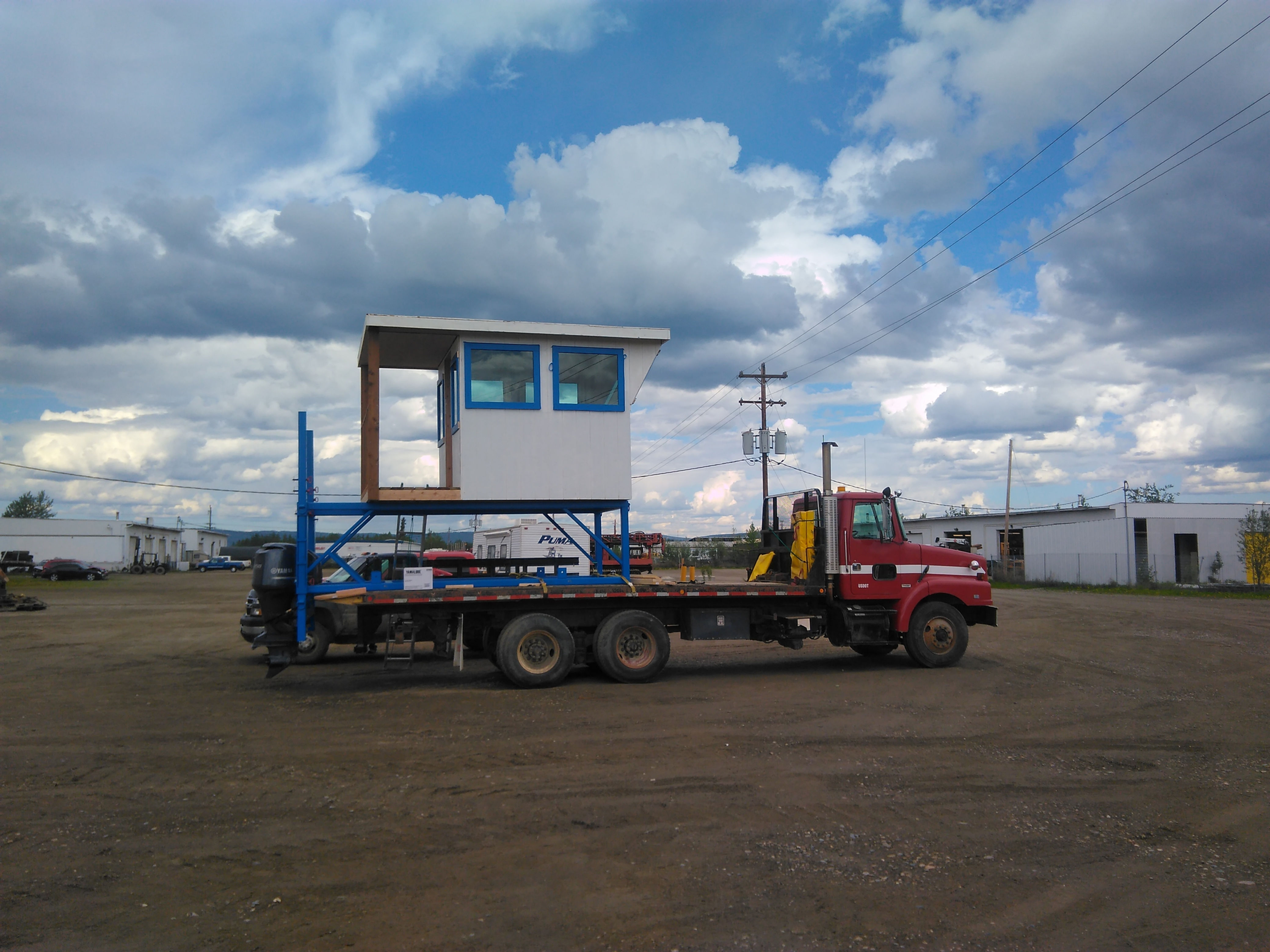 Red Yukon transport truck with crane attachment